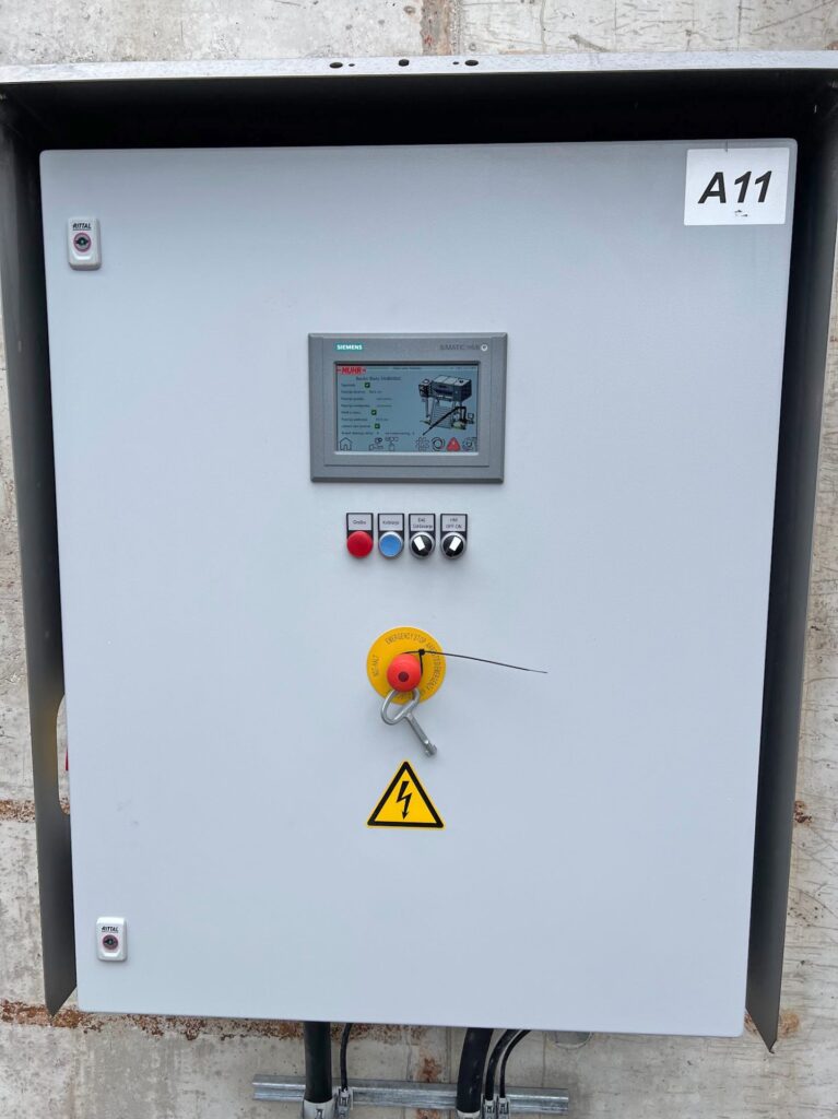 Siemens Simatic HMI Schaltschrank mit Display, Not-Aus-Schalter, Steuerungsknöpfen und Warnsymbol für elektrische Spannung.