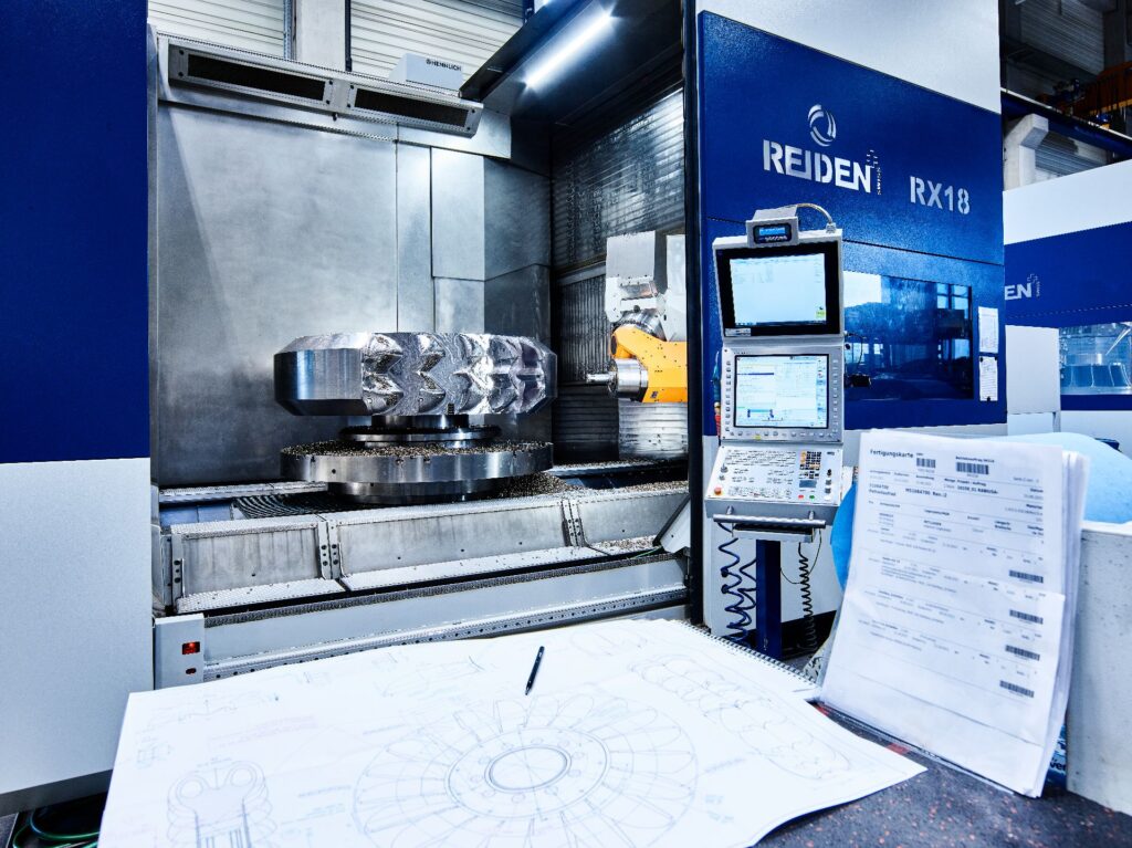 Präzisions-Fräsen eines Bauteils bei Global Hydro Austria mit einer Reiden RX18 CNC-Maschine und technischen Zeichnungen.