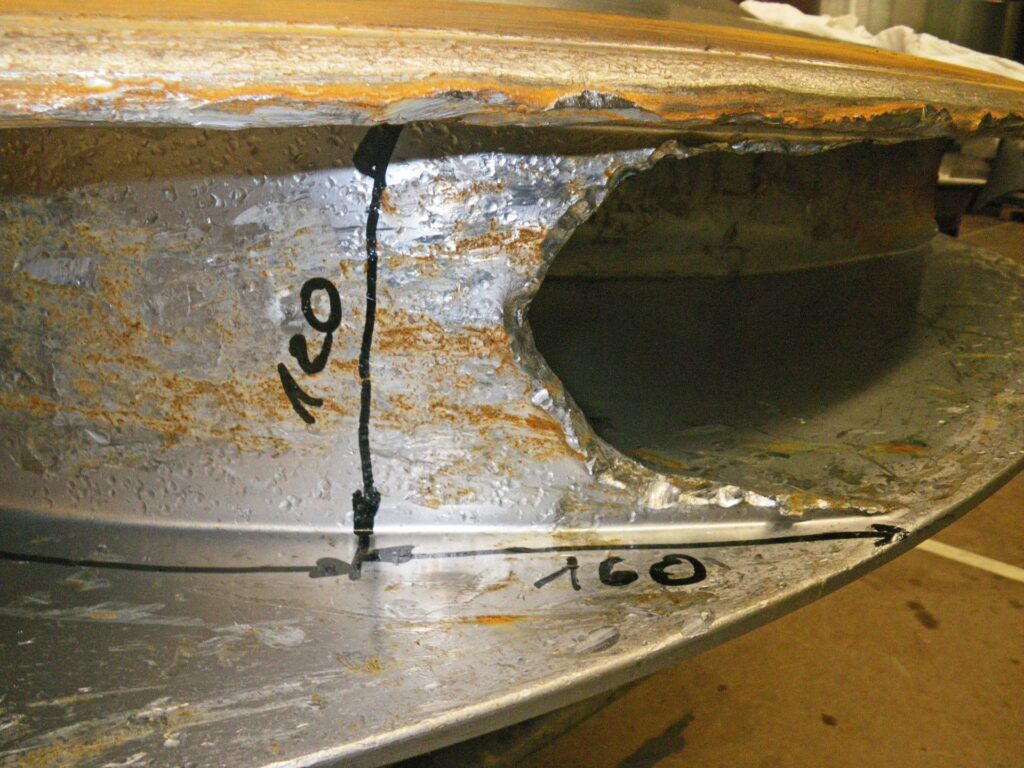 Großer KWO-Materialschaden an Metallbauteil mit Korrosion und markierten Maßen 120 und 160 zur Dokumentation.
