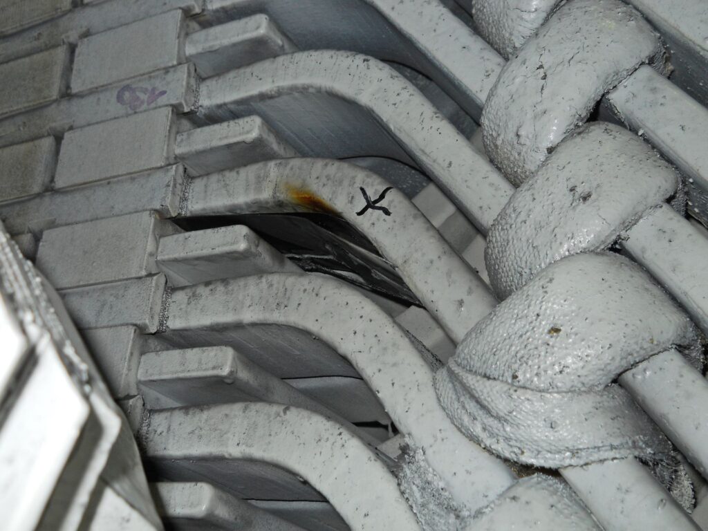 Beschädigte Wicklung am Stator einer KWO-Industriemaschine mit Brandspuren und schwarzer Markierung an der Schadstelle.