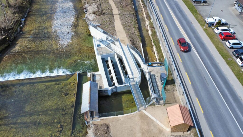 Luftaufnahme Kraftwerk Bärau: Wehr- und Fischpassanlage an der Ilfis neben einer befahrenen Hauptstrasse im Emmental.