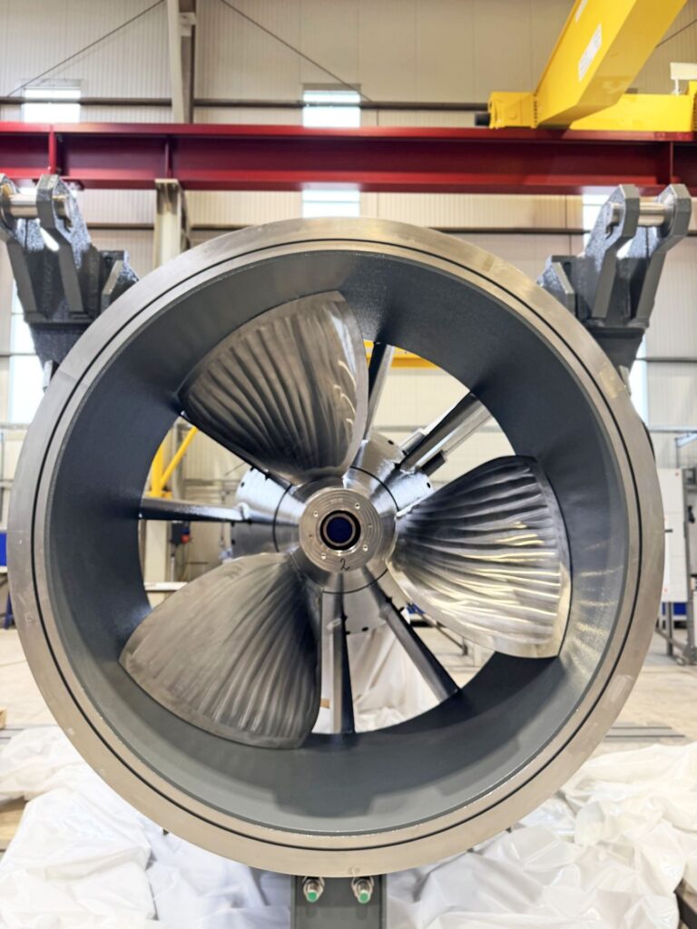 Nahaufnahme einer Schiffsschraube im Düsenring während der Werksmontage in einer Industriehalle.