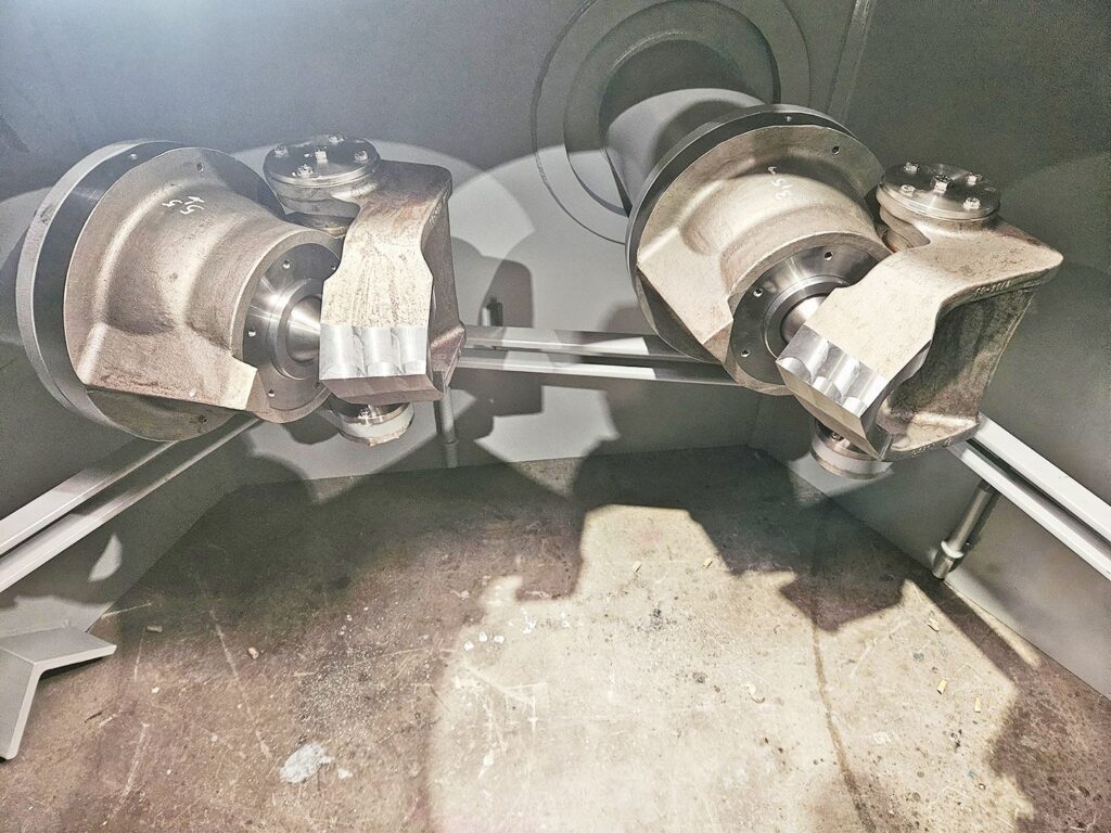 Innenleben einer Mega Rema Turbine mit zwei massiven Metallrotoren und Wellen in einer industriellen Fertigungshalle.