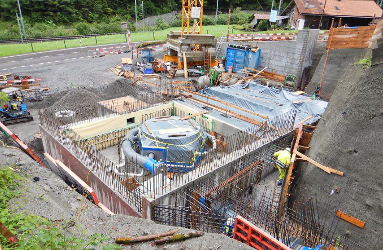 Baustelle des Krafthauses KW Sousbach mit Armierungseisen, Betonschalungen und blauer Turbine im Rohbau.