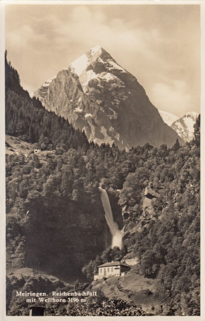 Historische Postkarte von Meiringen mit dem Reichenbachfall vor dem massiven, schneebedeckten Gipfel des Wellhorns.