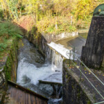 Nach der Turbinierung wird das Triebwassser der Anlage in den Puchhammerkanal (rechts im Bild) und den sogenannten Fallbach (linkes Gerinne) Richtung Salzach geleitet. KW Deisl Streichwehr
