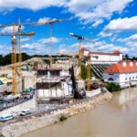 Für die Baugrubenumschließung des neuen Maschinengebäudes wurden abdichtende Schlitzwände 70 m tief in den Boden abgeteuft. KW Töging Bauphase Krafthaus 2