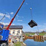 Einheben der neuen Wehrklappe in Fischbauchausführung im April 2022. Kraftwerk Lienz Einheben Wehrklappe