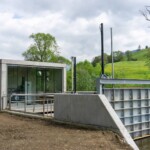Einlaufbereich an der Wasserfassung mit Absperrschütz und Sichtfenster auf das Hydraulikaggregat und die E-
Technik im Inneren. Das gesamte Stahlwasserbauequipment lieferte der steirische Branchenspezialist S.K.M. GmbH. Kraftwerk Pewag Technikgebäude Einlauf