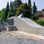 Die Formgebung des architektonisch gestalteten Maschinengebäudes stellt einen Fisch dar und steht für den ökologischen Projektcharakter. Kraftwerk Sinnhub Titelbild 1