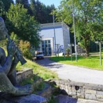 Der zugehörige Brunnen ist zwar nicht mehr in Betrieb, aber der „Flötenspielende Knabe“ neben dem Gebäude des Pumpspeicherkraftwerks Oberberg 1 ist immer noch ein Blickfang. Ruselkraftwerke